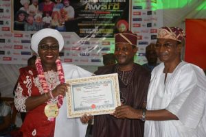 Wife of the Ondo state Governor, Arabinrin Betty Anyanwu - Akeredolu (Left) receiving an award ' Ondo State Outstanding Recognition Award' from the Publiher of Heros International Magazine, Dr Sunday Akinbiola ( middle), during the 5th Ondo State Female Role Model award-an event put together in conjunction with Heros International Magazine. in Akure, on Sunday, 4th Feb, 2018.