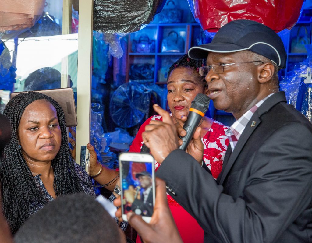 Hon. Minister of Power, Works & Housing, Mr Babatunde Fashola,SAN (right),Managing Director/CEO, Rural Electrification Agency(REA), Mrs Damilola Ogunbiyi (right) and benefitting shop owner, Mrs Ngozi Joel (middle) during the inspection of the  electrified shops under the Federal Government 's Energizing Economies Initiative at Ariaria market Aba, Abia State on Thursday 17th May 2018.  