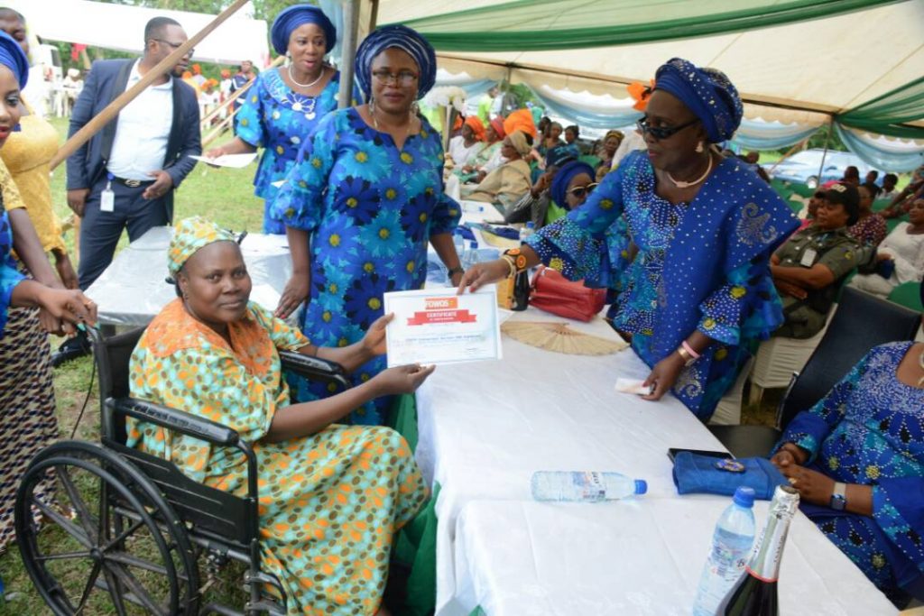 Wife of Ondo State Governor, Arabinrin Betty Anyanwu-Akeredolu (right), presenting certificate to one of the beneficiaries (left), during the 6th Forum for Wives of Ondo State Officials, (FOWOSO) Empowerment Outreach Programme for Women, Youths and Special needs people in Akure North Local Government Area of Ondo State. 21st, June, 2018.