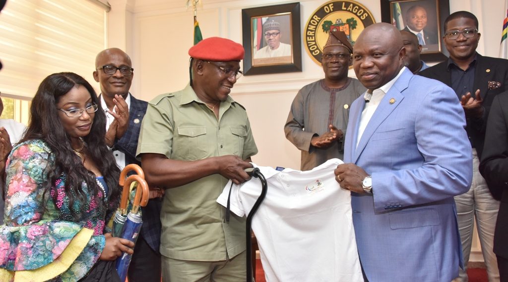 Lagos State Governor, Mr. Akinwunmi Ambode (right), being presented with a T-shirt by Minister of Youth and Sports, Mr. Solomon Dalung during a courtesy visit by the Sports Minster and delegation from the International Paralympics Committee at Lagos House, Alausa, Ikeja, on Thursday, June 7, 2018. With them: President, Nigeria Para-Powerlifting Federation, Mrs. Queen Ubah (left); Chairman, Lagos State Sports Commission, Mr. Kweku Tandoh (2nd left); Permanent Secretary, Lagos State Ministry of Youth & Social Development, Mr. Hakeem Muri-Okunla (right behind) and Commissioner for Special Duties & Inter-Governmental Relations, Mr. Oluseye Oladejo (middle behind).